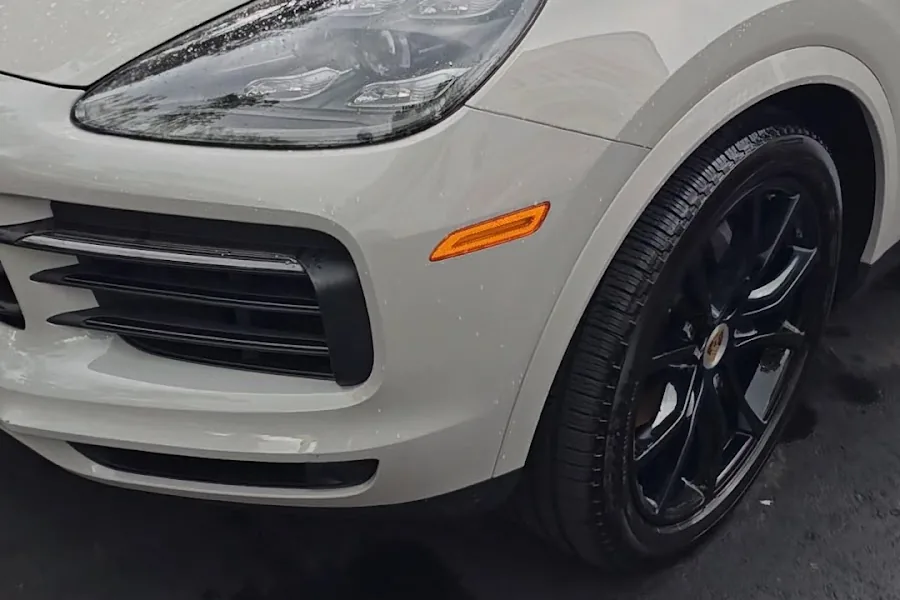 The front quarter of a white Porsche Cayenne after a Rashine detail