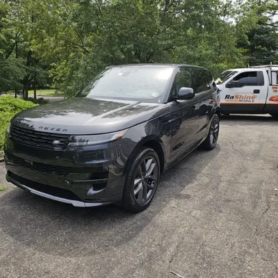 A Range Rover on a driveway with the Rashine Mobile truck parked behind it