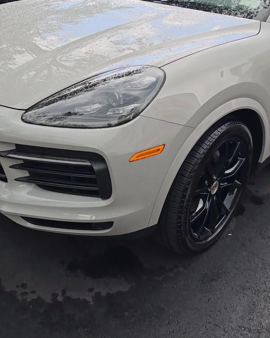A white Porsche Cayenne freshly detailed by Rashine, paint still wet-looking in the light