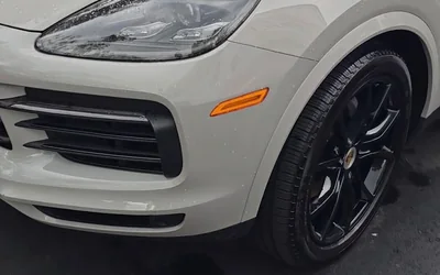 A white Porsche Cayenne, front wheel and fender, after a detail