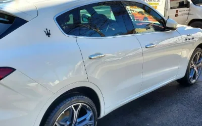 A white Maserati Levante finished on a residential street