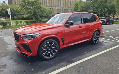 A red BMW X5 M, front three-quarter, paint clean and reflective